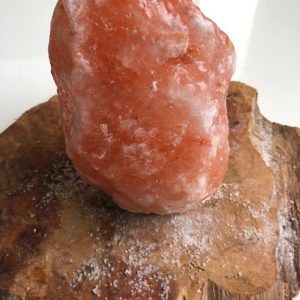 Himalayan Salt Lamp with health benefits on wooden tray